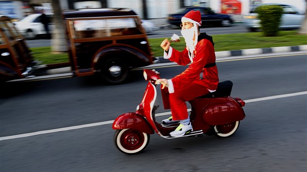 A man in a Santa Claus costume drives his Vespa during a parade at the main coastal avenue in southern port city of Limassol, Cyprus, Sunday, Dec. 14, 2014. Around 1000 people in Santa Claus costumes take part in this parade during Christmas celebrations.