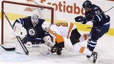 Ondej Pavelec z Winnipegu elí anci Matta Reada z Philadelphie..