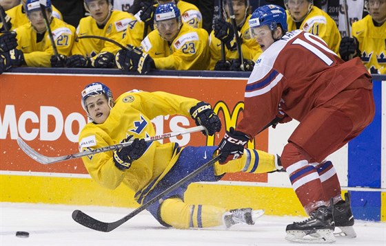 William Nylander ze védska padá po obranném zásahu eského juniora Davida...