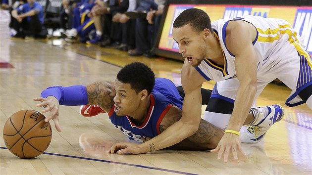 K. J. McDaniels (vlevo) z Philadelphie a Stephen Curry z Golden State bojuj o m.