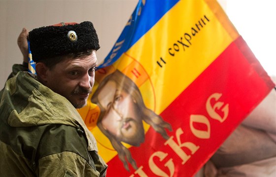 Ruský kozák ukazuje zástavu své jednotky v obci Stachanov na východ Ukrajiny...