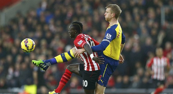 Sadio Mane (vlevo) ze Southamptonu v souboji s s Perem Mertesackerem z Arsenalu.