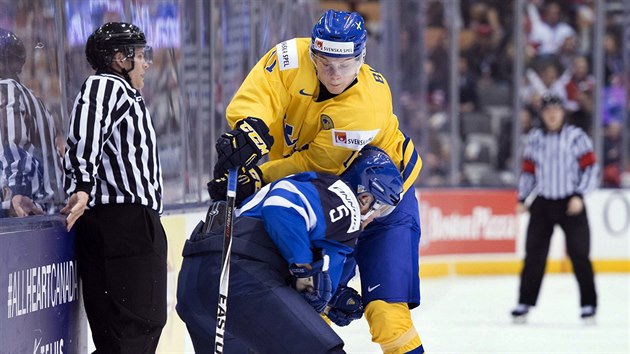 Momentka ze tvrtfinle MSJ v Kanad - vdsk hokejista Anton Blidh se sna dostat pes Fina Aleksi Makelu.