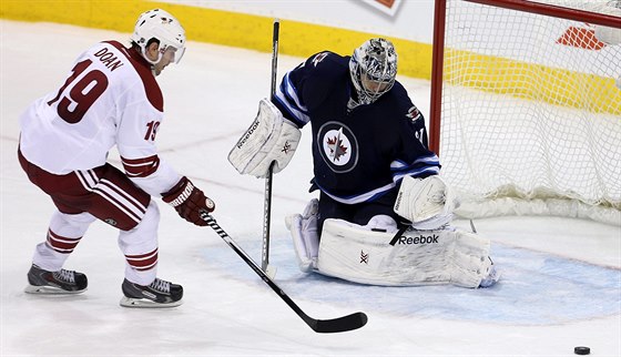 Branká Winnipegu Ondej Pavelec likviduje píleitost Shanea Doana z Arizony.