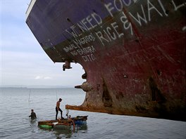 NA MLIN. Potápi ve mst Tacloban na Filipínách se snaí pomoct pi...