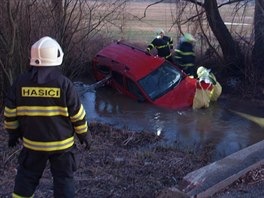 Hasii museli vyprostit havarovan vozidlo Dacia Logan z potoka u Komrova na...