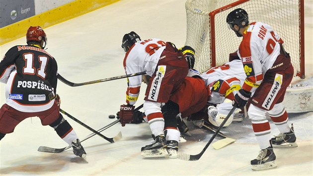 Tom Pospil z Hradce (vlevo) a Roman Rc z Olomouce (druh zleva) v souboji o puk ped olomouckou brankou.