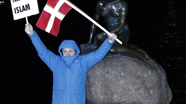Demonstrant pzuje ped sochou Mal mosk vly bhem protestu v Kodani (19. ledna 2015).