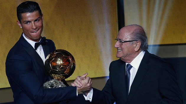 Portugalsk tonk Cristiano Ronaldo z Realu Madrid pebr Zlat m pro nejlepho fotbalistu svta, gratuluje f FIFA Sepp Blatter.