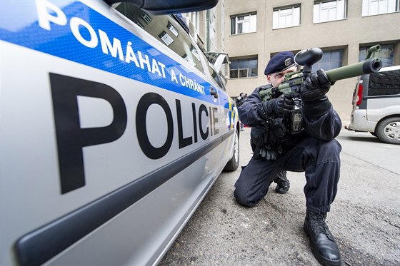 Policista ve speciální vest pedvádí takzvaný pepperball, který nábojem s...