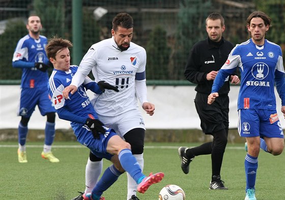 Ostravský Milan Baro (v bílém) prochází olomouckou obranou.