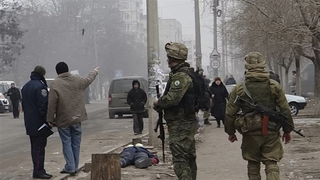 Ukrajint vojci ste ulici v Mariupolu, pobl tlo obti raketovho toku (24. ledna 2015).