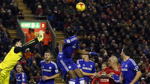 Martin krtel (v ervenm) z Liverpoolu hlavikuje na branku Chelsea, kterou hj Thibaut Courtois (ve lutm).