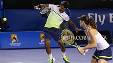 V ZÁPALU BOJE. Leander Paes se opírá do úderu,  Martina Hingisová pihlíí.