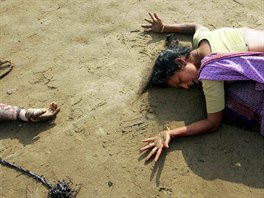 An Indian woman mourns the death of her relative (L) who was killed in the...