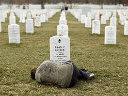 Lesleigh Coyer, 25, of Saginaw, Michigan, lies down in front of the grave of...