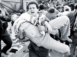An injured soccer fan is carried to safety by a friend after a wall collapsed...