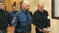 Justiční stráž přivádí Karla Veličku, který je žalován z ubodání starší ženy. Justiční stráž přivádí Karla Veličku, který je žalován z ubodání starší ženy.
