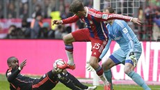 Thomas Müller z Bayernu Mnichov (uprosted) se snaí zakonit v duelu s...