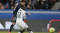 Ezequiel Lavezzi z Paris St. Germain (vlevo) petlail Dennise Appiaha z Caenu...