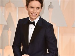 Eddie Redmayne v modrm obleku Alexander McQueen, ernm motlkem a platinovmi...