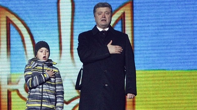 Prezident Petro Poroenko spolu se synem jednoho ze zabitch demonstrant poslouchaj ukrajinskou hymnu bhem vzpomnkov akce na lidi, kte padli bhem udlosti na Majdanu (20. nora 2015).