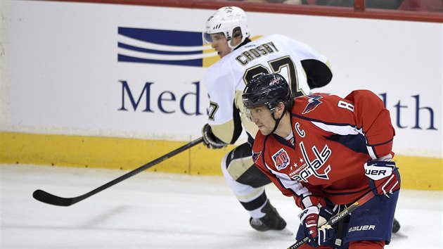 Sidney Crosby (v pozad) z Pittsburghu se pokou dostihnout Alexandra Ovekina z Washingtonu.