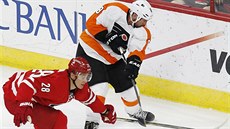 Alexander Semin (vlevo) z Caroliny a Nicklas Grossmann z Philadelphie bojují o...