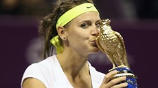 Lucie afáová líbá trofej pro vítzku turnaje v Dauhá.