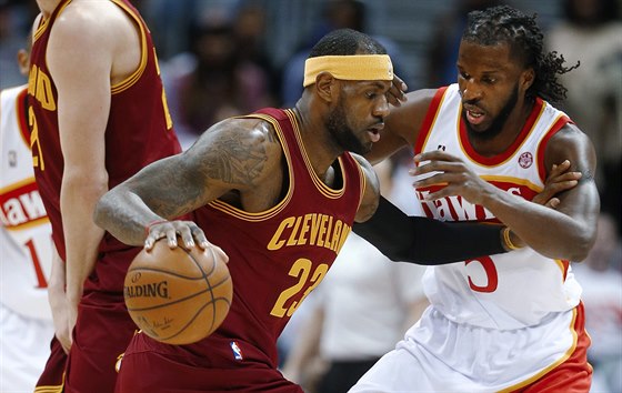 LeBron James z Clevelandu se pokouí prosadit, brání ho DeMarre Carroll z...