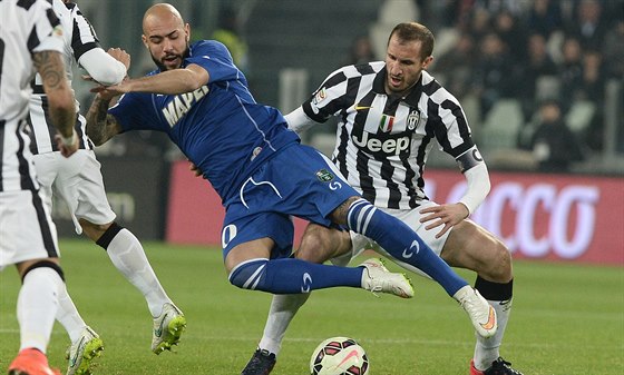 Simone Zaza (vlevo) ze Sassuola padá po stetu s Giorgim Chiellinim z Juventusu.