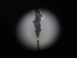 A heating station chimney is seen through a hole in a steel wall at...