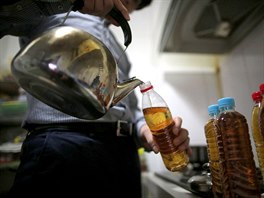 Korean J.Kim fills a bottle with herb tea, which was recommended to him by his...