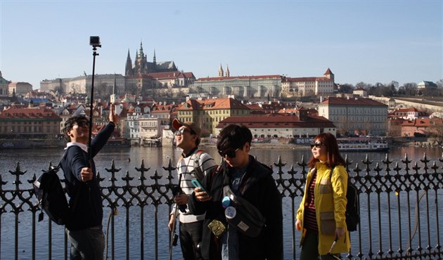 Cizinci fotí selfie s panoramatem Prahy.