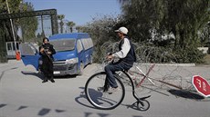 Cyklista projídí kolem kolem policisty u muzea Bardo, kde ve stedu útoili...