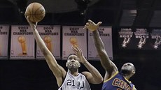 Tim Duncan (vlevo) ze San Antonia se prodírá pes LeBrona Jamese z Cavaliers.