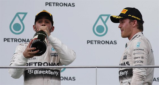 Lewis Hamilton si dává douek ampaského, týmový kolega Nico Rosberg ho se...