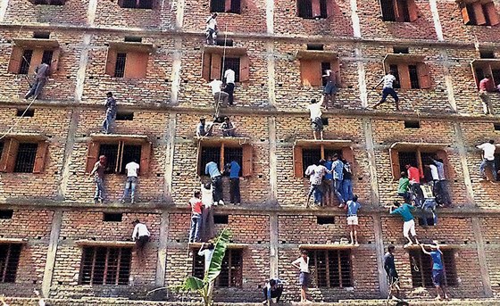 V Indii lidé lezou po zdi budovy, aby radili studentm u práv probíhajících...
