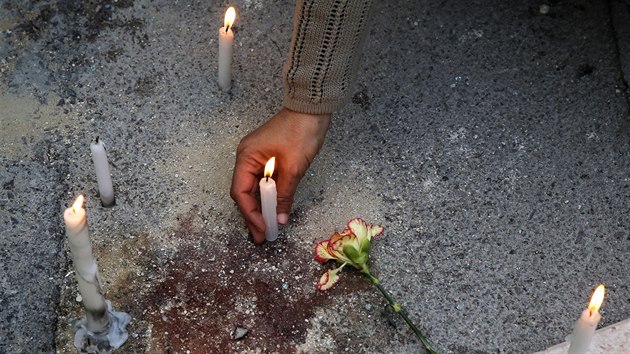 Lid zapaluj svky v Tunisu na mst teroristickho toku (19. bezna 2015).