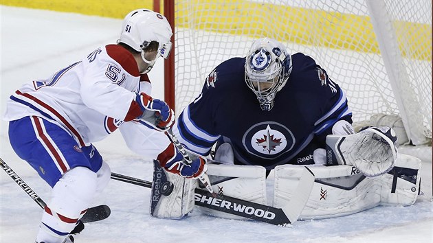 Ondej Pavelec hld brnaku Winnipegu ped Davidem Desharnaisem z Montrealu.