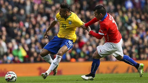 Brazilsk tonk Neymar (vlevo) je faulovn chilskm reprezentantem Garym Medelem.