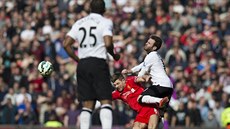 Tvrdý stet Stevena Gerrarda (dole) z Liverpoolu s Juanem Matou z Manchesteru...