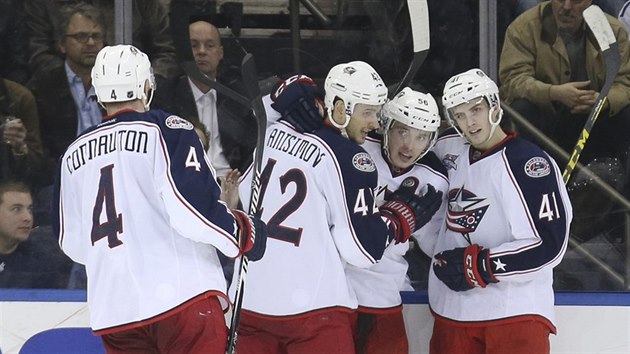 Slovensk tonk Marko Dao (druh zprava) z Columbusu slav se spoluhri, pokoil glmana Henrika Lundqvista z NY Rangers.