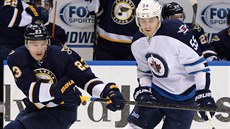 Dmitrij Jakin (vlevo) ze St. Louis a Mark Scheifele z Winnipegu sledují puk.