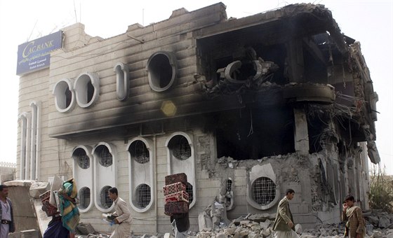 Lidé vynáí vci z budovy banky v Saad, která byla zasaena pi leteckém úderu...