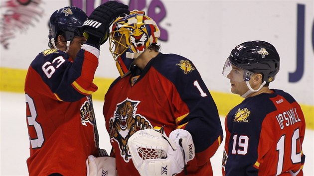 POCHVALA. Brank Roberto Luongo z Floridy sklz uznn spoluhr. Vlevo je Dave Bolland, vpravo Scottie Upshall.