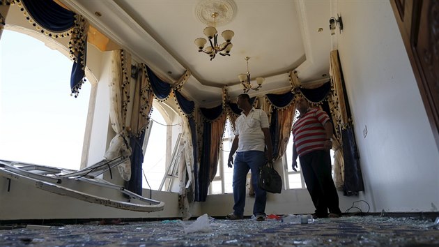 Lid stoj v pokoji, kter byl ponien pi leteckm der spojenc na blzk sklad zbran v Sanaa (18. dubna 2015).