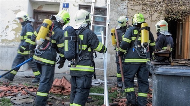 Hasii se chystaj k rozbrn stechy rodinnho domu v Ivanovicch na Han, kter v nedli zniil por. (13. 4. 2015)