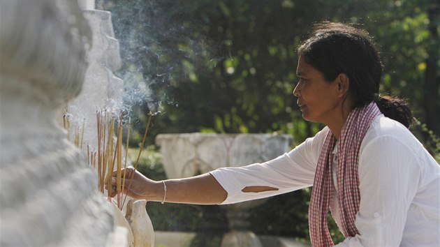 ena zapaluje vonn tyinky bhem budhistickho obadu k uctn pamtky zavradnch obyvatel Kambodi. (17. dubna 2015)