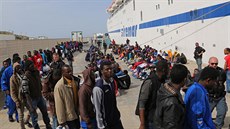 Migranti ekají na ostrov Lampedusa na nastoupení na lo, která je peveze na...